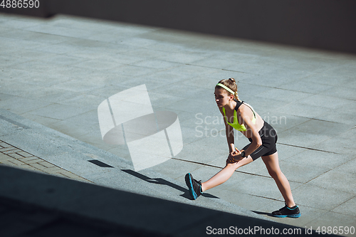 Image of Female runner, athlete training outdoors in summer\'s sunny day.