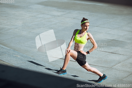 Image of Female runner, athlete training outdoors in summer\'s sunny day.