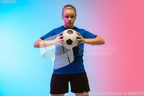 Image of Female soccer, football player training in action isolated on gradient studio background in neon light