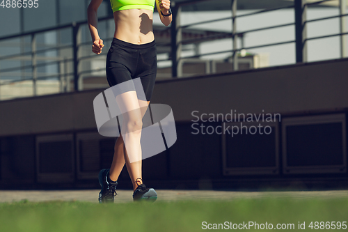 Image of Female runner, athlete training outdoors in summer\'s sunny day.