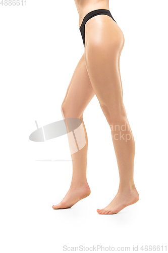 Image of Beautiful female legs isolated on white background. Sportive, sensual body with well-kept skin in underwear.