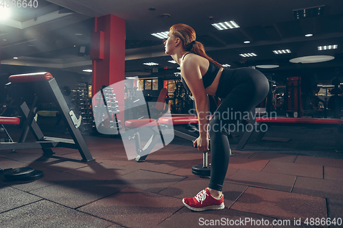 Image of Young muscular caucasian woman practicing in gym with equipment. Wellness, healthy lifestyle, bodybuilding.