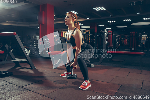 Image of Young muscular caucasian woman practicing in gym with equipment. Wellness, healthy lifestyle, bodybuilding.