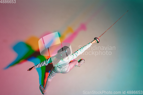 Image of Teen girl in fencing costume with sword in hand on gradient background with neon light, top view