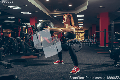 Image of Young muscular caucasian woman practicing in gym with equipment. Wellness, healthy lifestyle, bodybuilding.