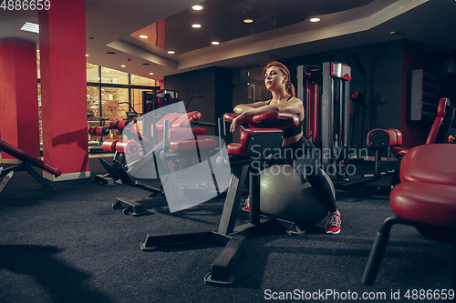 Image of Young muscular caucasian woman practicing in gym with equipment. Wellness, healthy lifestyle, bodybuilding.