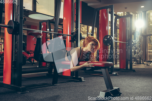 Image of Young muscular caucasian woman practicing in gym with equipment. Wellness, healthy lifestyle, bodybuilding.