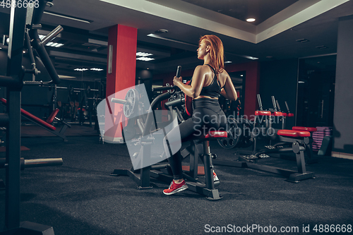 Image of Young muscular caucasian woman practicing in gym with equipment. Wellness, healthy lifestyle, bodybuilding.