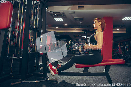 Image of Young muscular caucasian woman practicing in gym with equipment. Wellness, healthy lifestyle, bodybuilding.