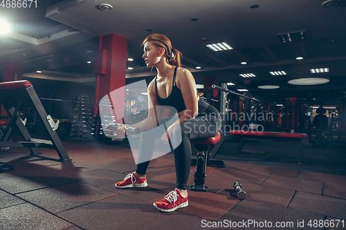 Image of Young muscular caucasian woman practicing in gym with equipment. Wellness, healthy lifestyle, bodybuilding.