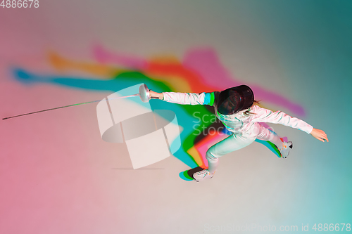 Image of Teen girl in fencing costume with sword in hand on gradient background with neon light, top view