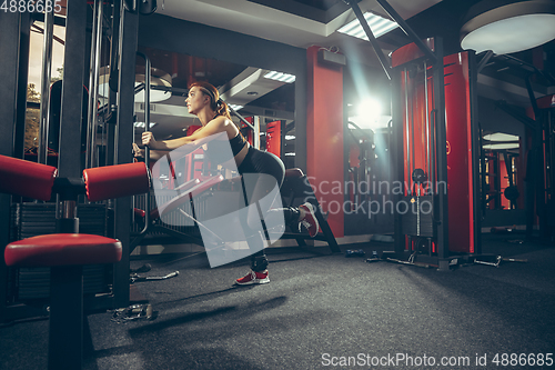 Image of Young muscular caucasian woman practicing in gym with equipment. Wellness, healthy lifestyle, bodybuilding.