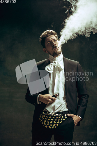 Image of Young man as Dorian Gray on dark background. Retro style, comparison of eras concept.