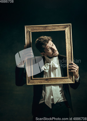 Image of Young man as Dorian Gray on dark background. Retro style, comparison of eras concept.