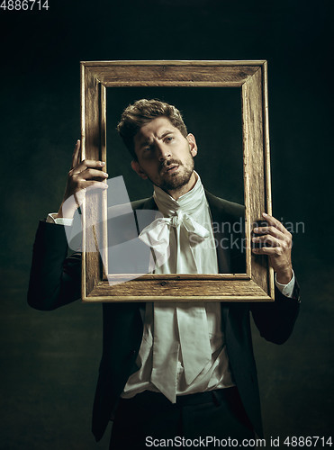 Image of Young man as Dorian Gray on dark background. Retro style, comparison of eras concept.