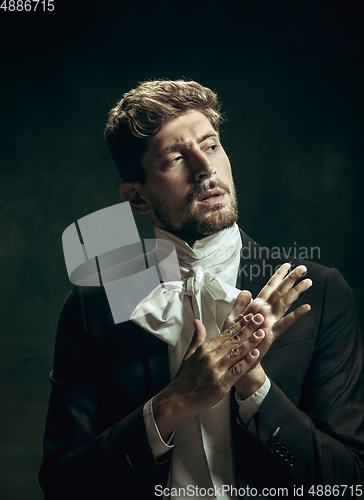 Image of Young man as Dorian Gray on dark background. Retro style, comparison of eras concept.