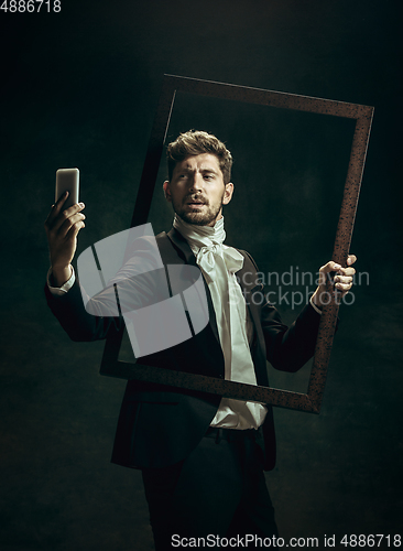 Image of Young man as Dorian Gray on dark background. Retro style, comparison of eras concept.