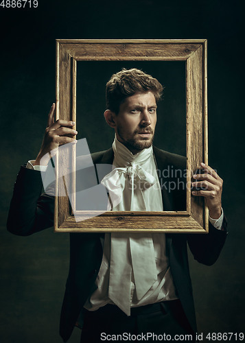 Image of Young man as Dorian Gray on dark background. Retro style, comparison of eras concept.