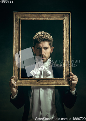 Image of Young man as Dorian Gray on dark background. Retro style, comparison of eras concept.