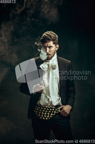 Image of Young man as Dorian Gray on dark background. Retro style, comparison of eras concept.