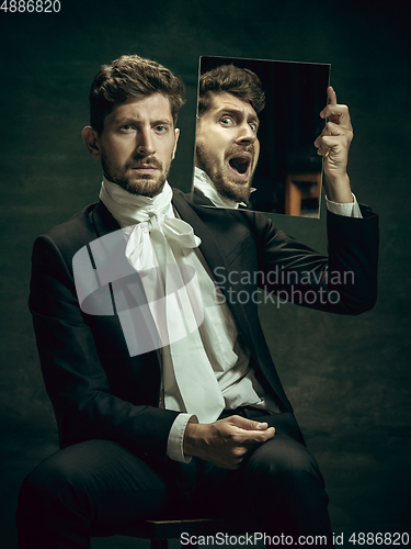 Image of Young man as Dorian Gray on dark background. Retro style, comparison of eras concept.