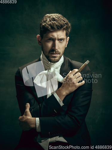 Image of Young man as Dorian Gray on dark background. Retro style, comparison of eras concept.