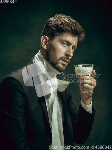 Image of Young man as Dorian Gray on dark background. Retro style, comparison of eras concept.