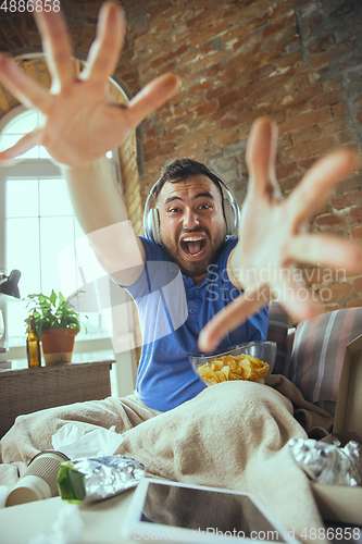 Image of Lazy man living the whole life in his bed surrounded with messy