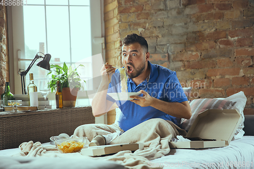 Image of Lazy man living the whole life in his bed surrounded with messy