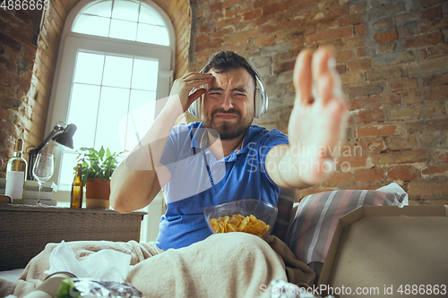 Image of Lazy man living the whole life in his bed surrounded with messy