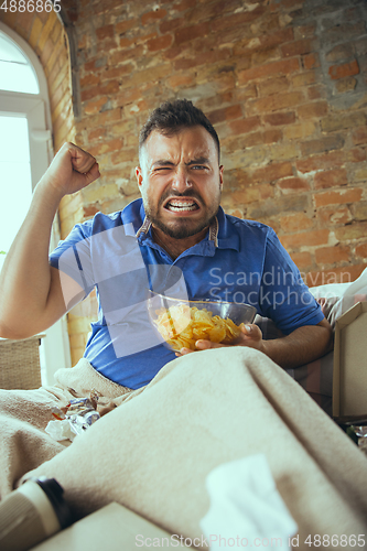 Image of Lazy man living the whole life in his bed surrounded with messy