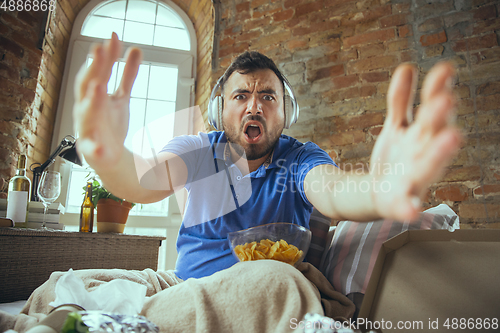 Image of Lazy man living the whole life in his bed surrounded with messy