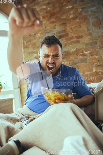 Image of Lazy man living the whole life in his bed surrounded with messy