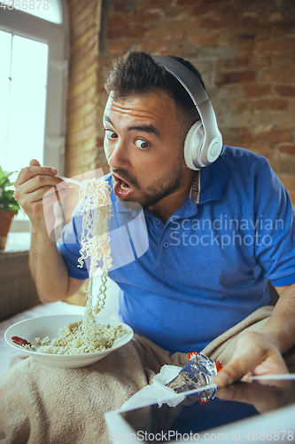 Image of Lazy man living the whole life in his bed surrounded with messy