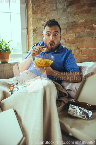 Image of Lazy man living the whole life in his bed surrounded with messy