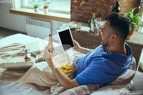 Image of Lazy man living the whole life in his bed surrounded with messy