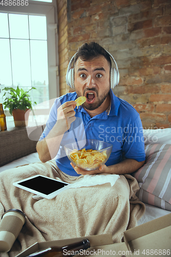 Image of Lazy man living the whole life in his bed surrounded with messy