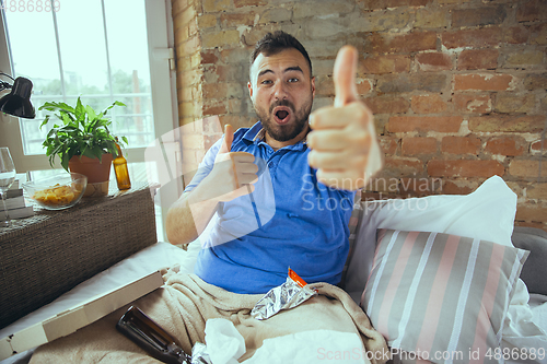 Image of Lazy man living the whole life in his bed surrounded with messy