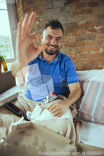 Image of Lazy man living the whole life in his bed surrounded with messy