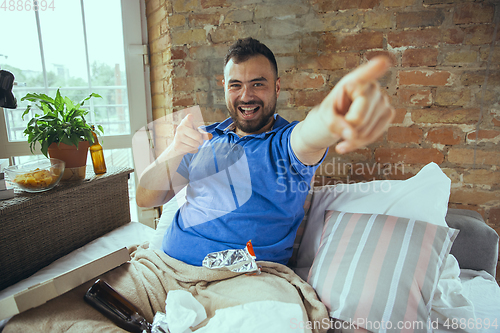 Image of Lazy man living the whole life in his bed surrounded with messy