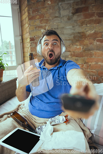 Image of Lazy man living the whole life in his bed surrounded with messy