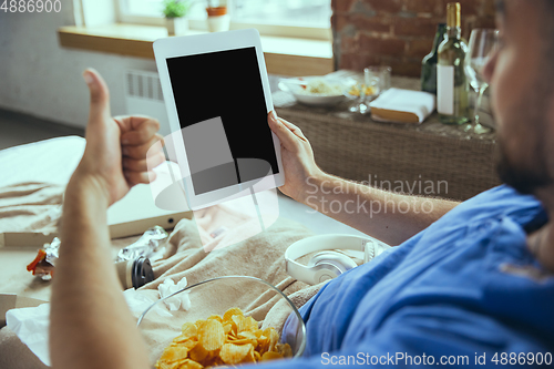 Image of Lazy man living the whole life in his bed surrounded with messy