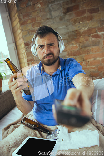 Image of Lazy man living the whole life in his bed surrounded with messy