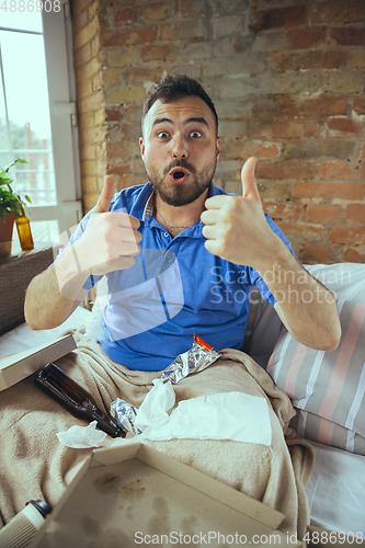 Image of Lazy man living the whole life in his bed surrounded with messy