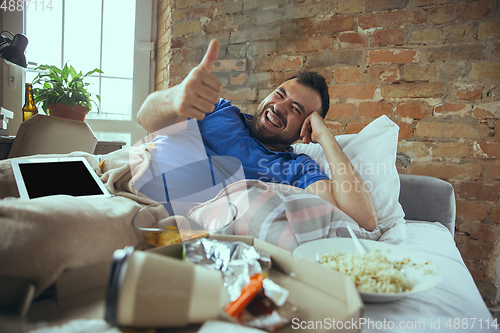 Image of Lazy man living the whole life in his bed surrounded with messy