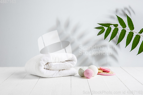 Image of Beautiful spa composition on massage table in wellness center, copyspace. Leaves\' shadows on the wall