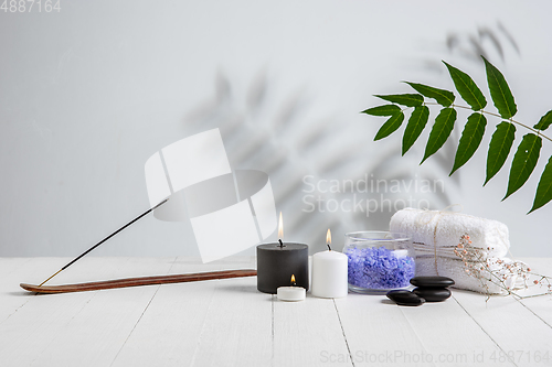 Image of Beautiful spa composition on massage table in wellness center, copyspace. Leaves\' shadows on the wall