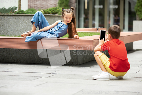 Image of Two smiling kids, boy and girl taking photo together in town, city in summer day