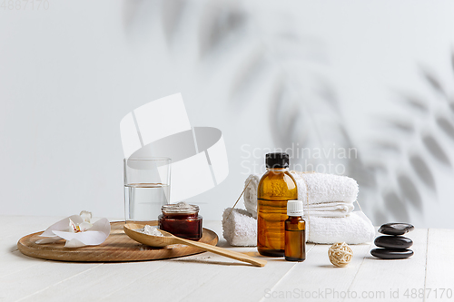 Image of Beautiful spa composition on massage table in wellness center, copyspace, leaves\' shadow