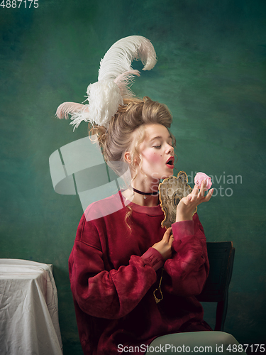 Image of Young woman as Marie Antoinette on dark background. Retro style, comparison of eras concept.